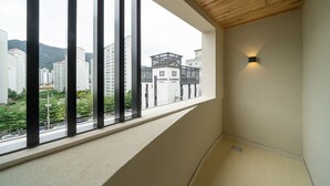 Habitación de hotel con un ventanal amplio, techo de madera y vistas a la ciudad.