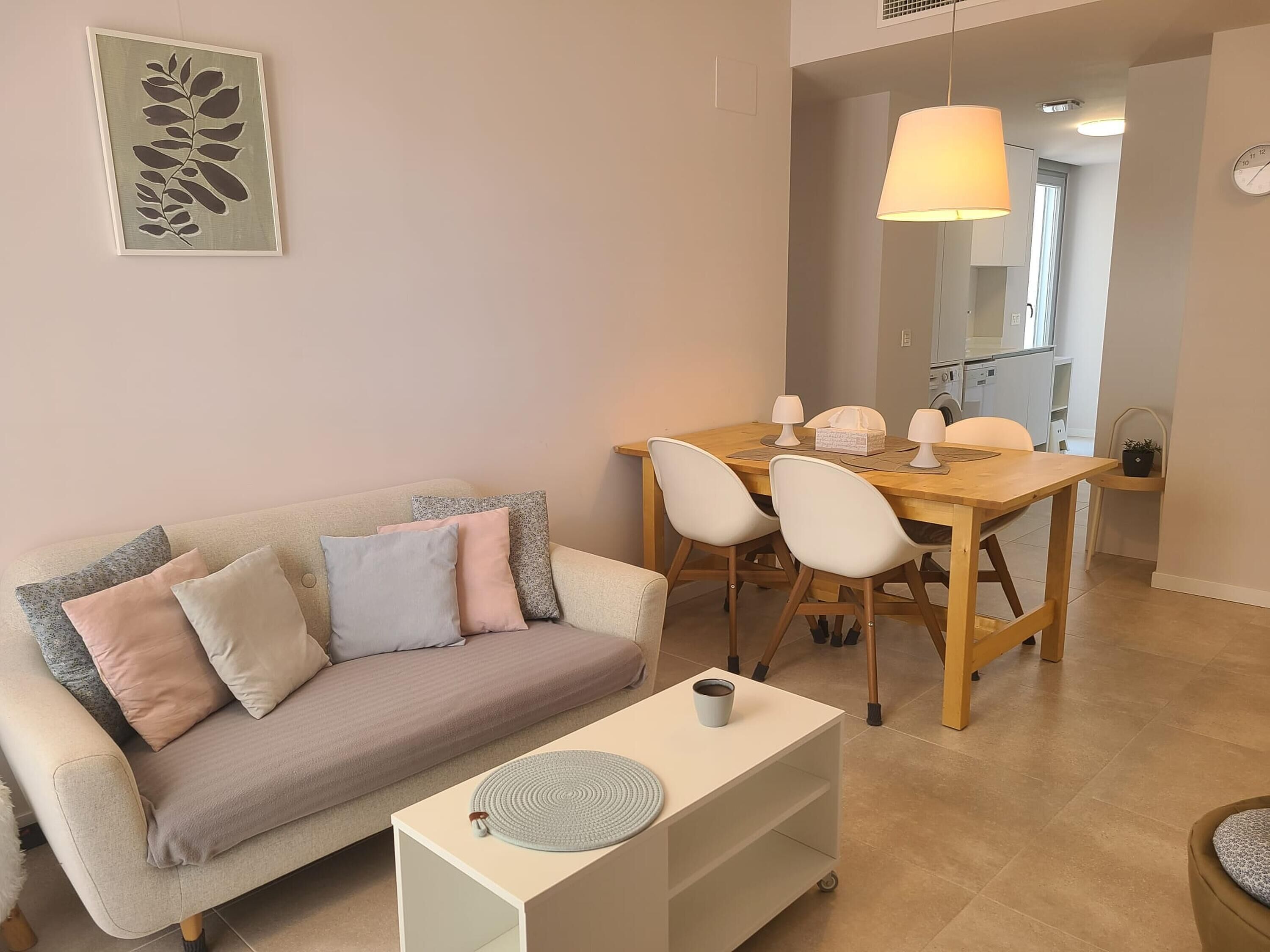 Un salon comprenant un canapé, une table basse et un coin repas avec des chaises et une table.