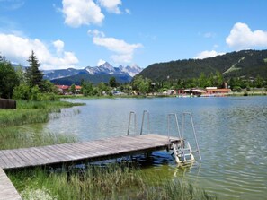 A wooden dock extending into a calm lake with mountains in the background. - Am Birkenhain by Interhome (Seefeld in Tirol)