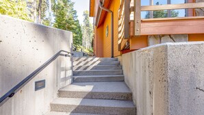 Un escalier en béton mène à un bâtiment en bois doté de grandes fenêtres.