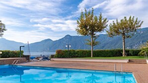 A swimming pool with a view of mountains and a body of water in the background. - Punta Grumo 2 by Interhome (Lierna)