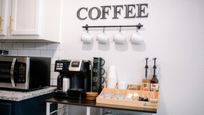Une cuisine équipée d’un coin café, comprenant une machine à café, des tasses et des condiments.