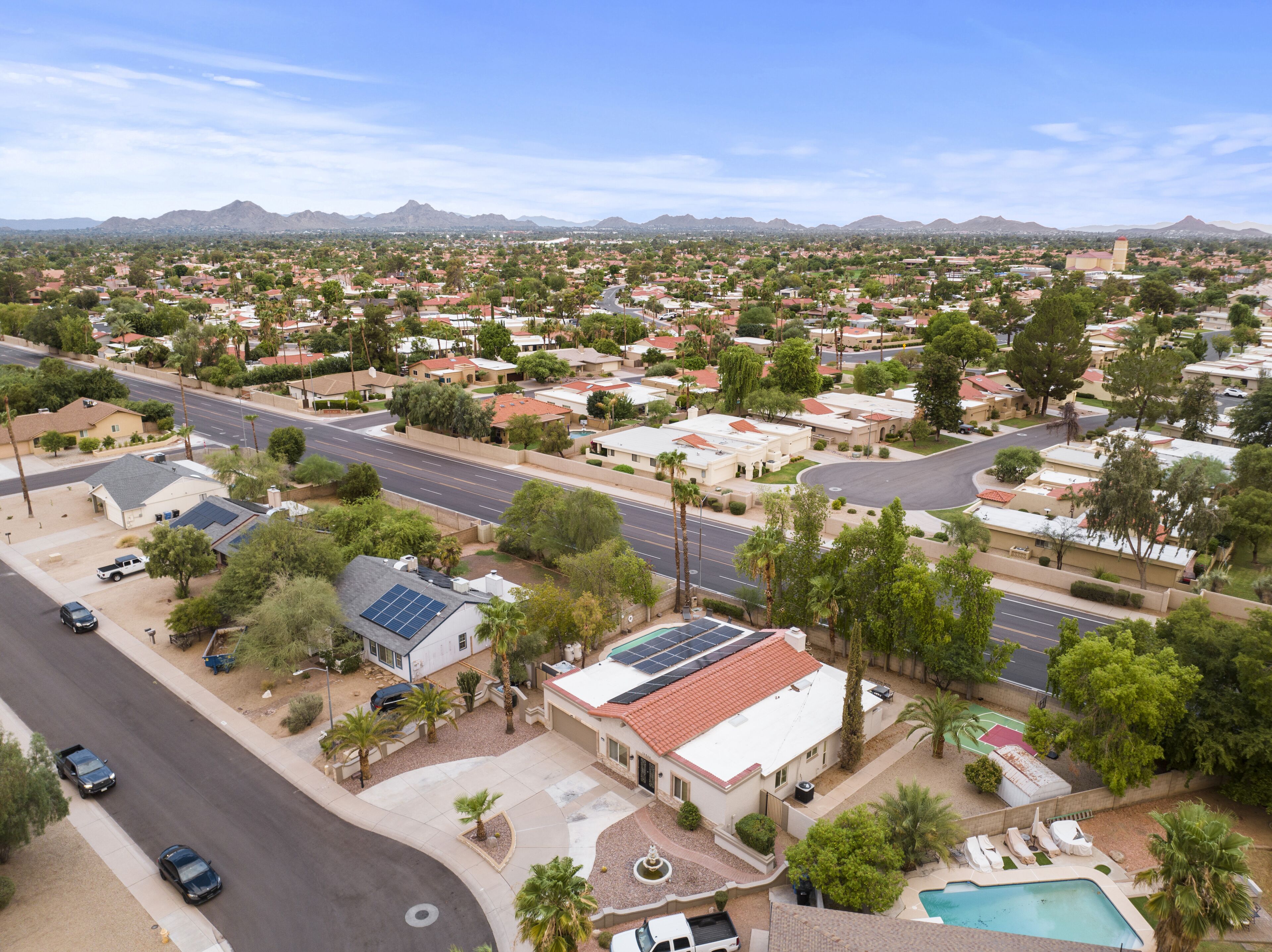A residential area with houses, roads, and a mountain range in the background.