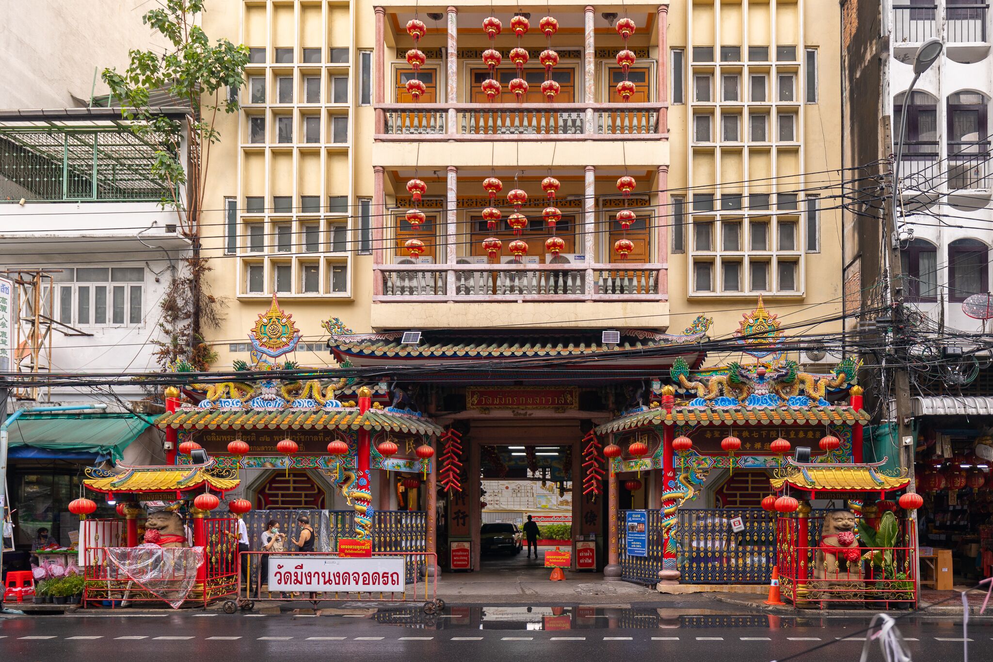 Un edificio tradicional con decoraciones elaboradas, un letrero y un pequeño santuario.