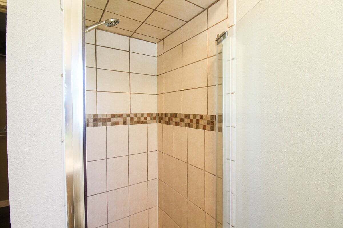 A tiled shower area with a checkered tile border.