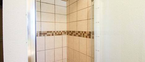 A tiled shower area with a checkered tile border.
