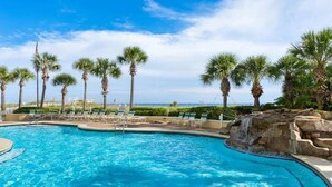A swimming pool with palm trees and a waterfall feature. - Jade East Towers 1120 (Destin)