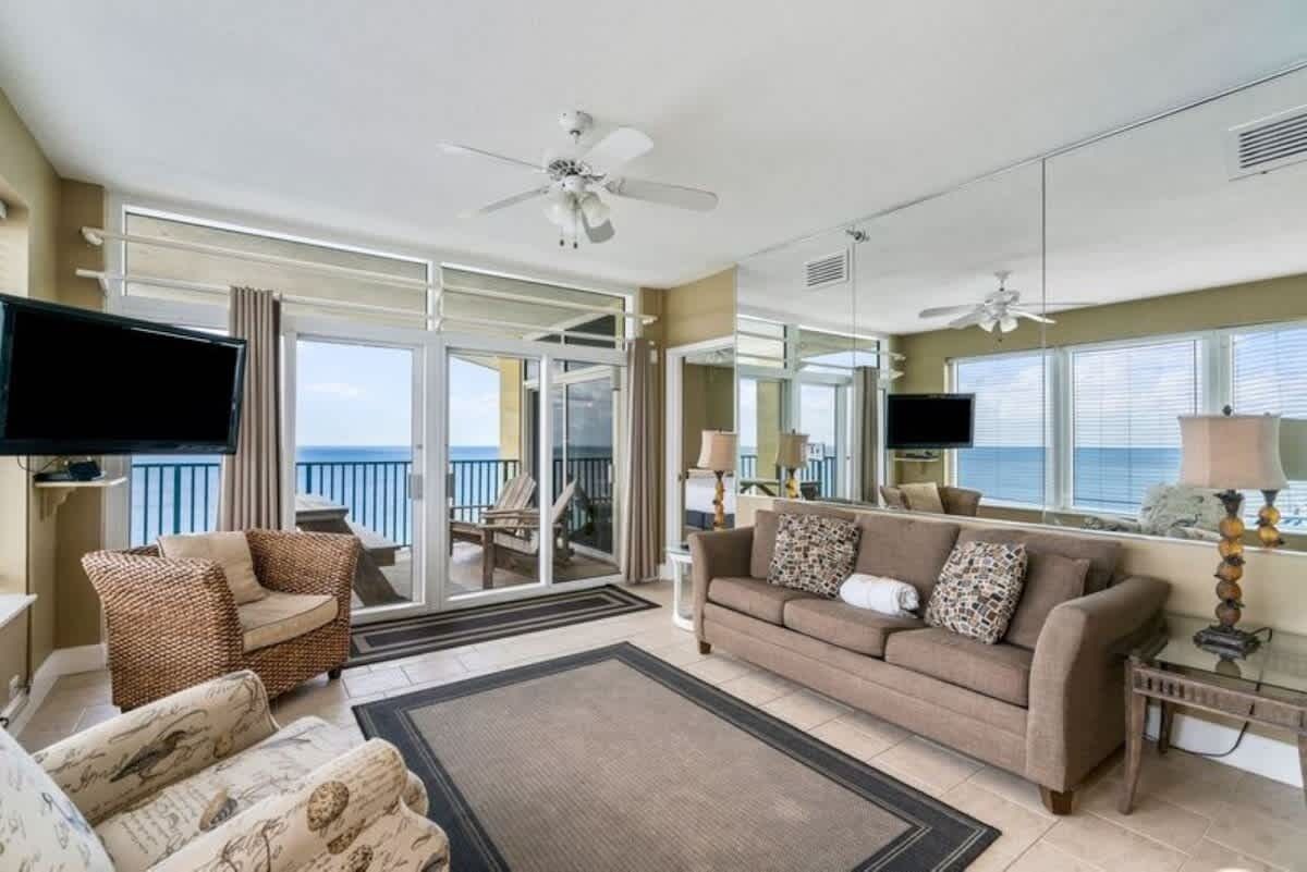 Ein geräumiges Wohnzimmer mit großem Flachbildfernseher, bequemen Sitzgelegenheiten und einem Balkon mit Aussicht.