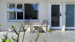 A building with a window, a door, and two chairs outside. - Brilliant Apt by Rottnest Ferry and Fremantle Oval (Fremantle)