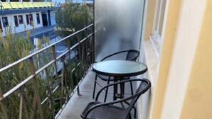 A balcony with a potted plant, two chairs, and a table. - Perfect Flat meters from WA Shipwrecks Museum (Fremantle)