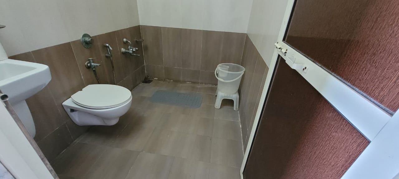 Un baño pequeño con inodoro, zona de ducha y lavabo.