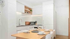 A compact kitchen with white cabinets, a microwave, and a sink. - Wanaka Town House - Single Malt (Albert Town)