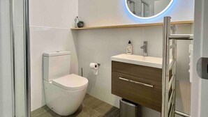 A modern bathroom with a toilet, sink, and mirror. - Wanaka Town House - Single Malt (Albert Town)