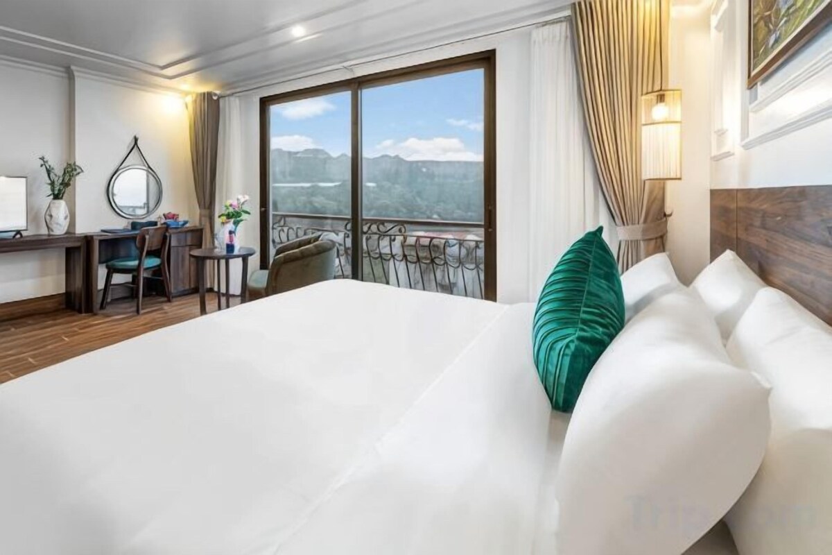 Een hotelkamer met een groot bed, een bureau en uitzicht op de bergen.