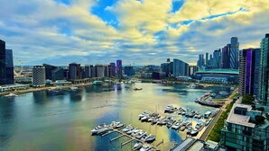 A marina with boats docked, surrounded by modern high-rise buildings and a waterfront promenade. - Ensuite Double Room with Private Bathroom and River View (Docklands)