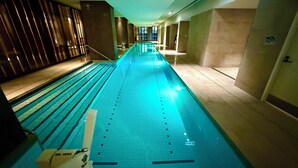 A long indoor swimming pool with clear lane markings, a lifeguard chair, and a sign indicating a weight limit of 150kg. - Ensuite Double Room with Private Bathroom and River View (Docklands)