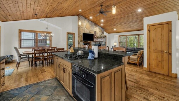Una cocina amplia con armarios de madera, una isla central y un salpicadero de piedra.