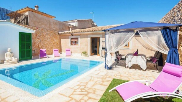 A pool area with a clear blue pool, a covered seating area with a table, and a statue. - ,,,,,kkkkkkkkkkkkkk (Petra)