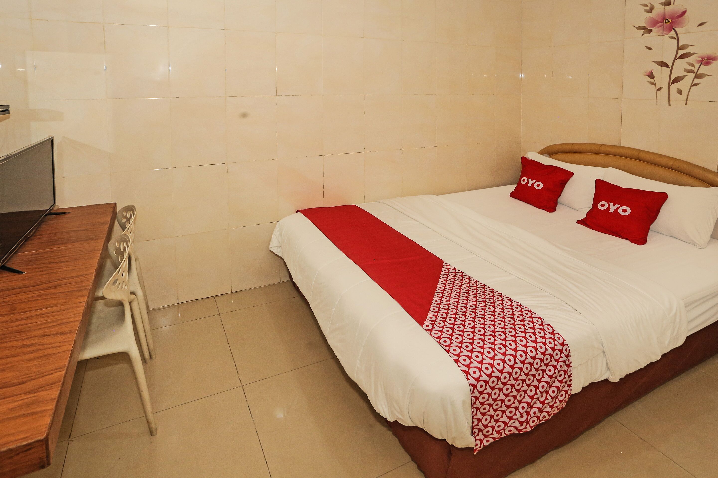 Una habitación de hotel con cama, escritorio y silla.