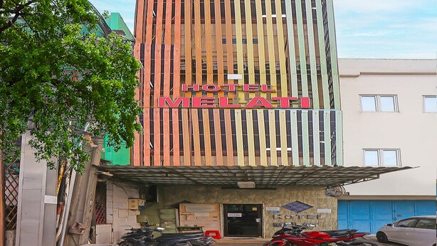 A hotel named "Hotel Melati" with a modern facade, a covered entrance, and several motorcycles parked in front. - Hotel O Melati (South Tangerang)