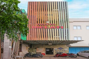 A hotel named "Hotel Melati" with a modern facade, a covered entrance, and several motorcycles parked in front. - Hotel O Melati (South Tangerang)