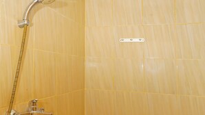 A small bathroom with a toilet, a shower, and tiled walls. - Hotel O Melati (South Tangerang)