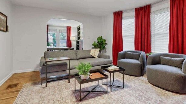 A modern living room with a sofa, two armchairs, a coffee table, and a rug. - The Ohio State of Mind - OSU-Themed 5BR Home in Clintonville (Columbus)
