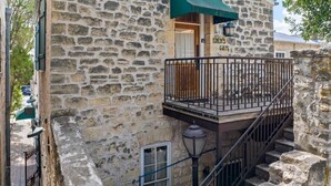 A stone building with a balcony, a staircase, and a door labeled 'EINSIGEN GATT.' - Romantic 1BR Suite on Main Street / Prime location (Fredericksburg)