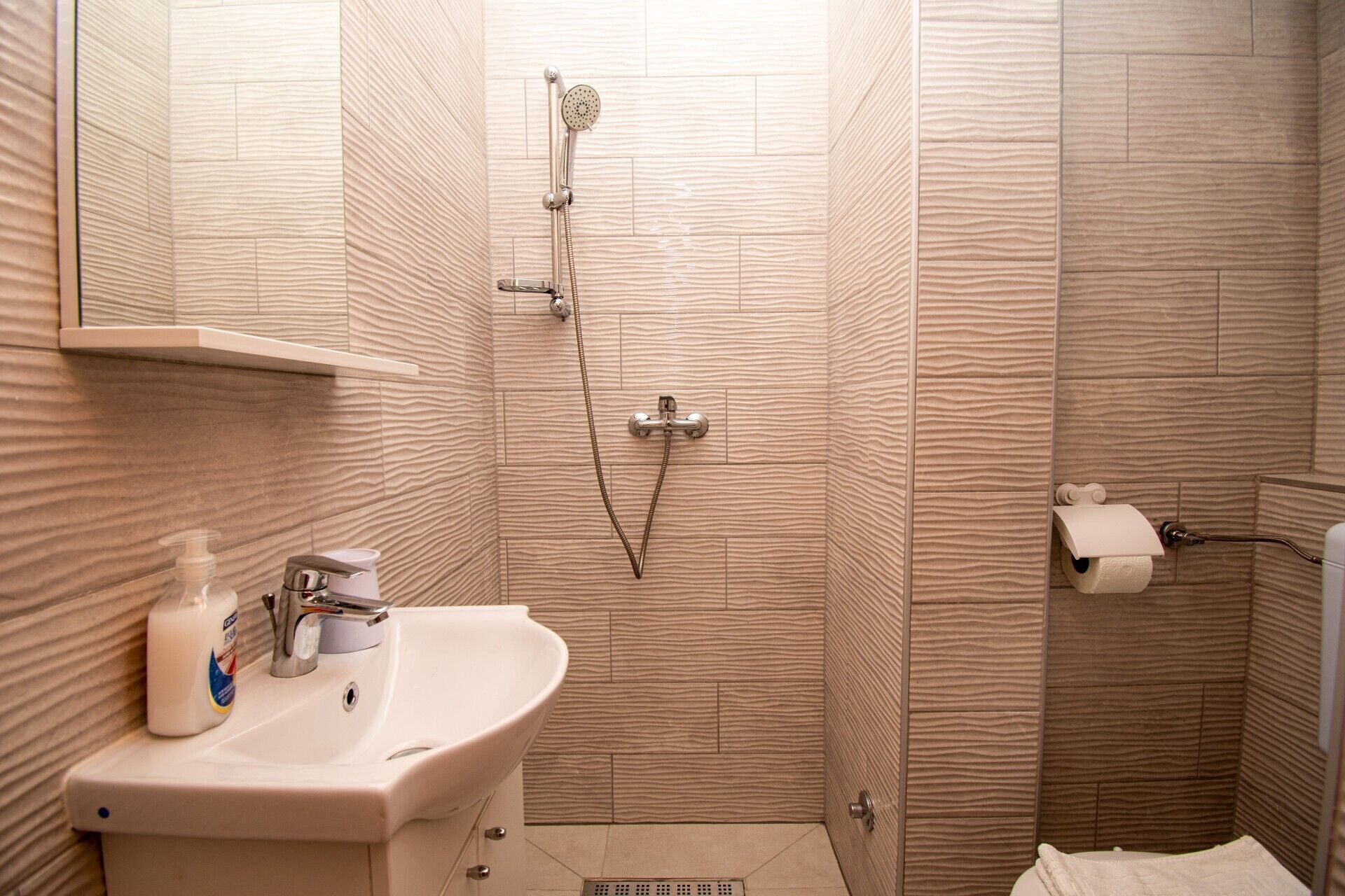 Un baño con lavamanos, inodoro y ducha.