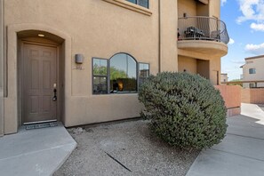 A building with a brown door, a small window, and a balcony with a railing. - Classy Condo Tucson (Tucson)