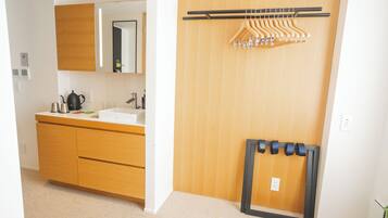 A modern bathroom with a wooden vanity, a mirror, and a towel rack.