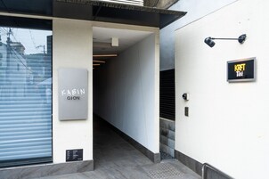 A modern building entrance with a sign for 'Kabin Gion' and a 'KRFT' sign.