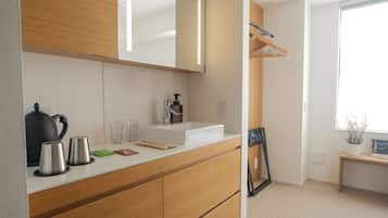 A modern bathroom with a white sink, wooden cabinets, a mirror, and a window with a view of the outdoors.