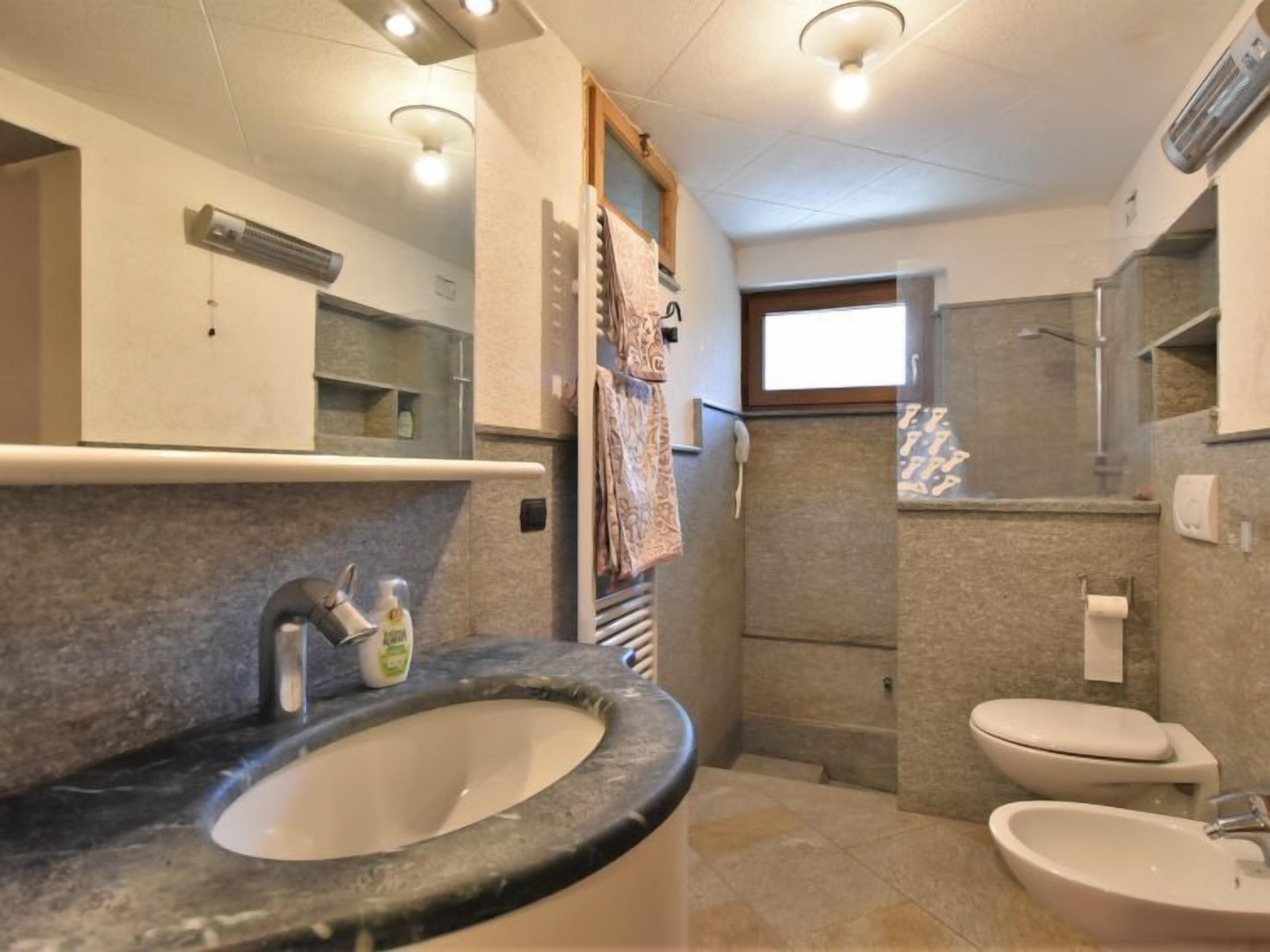 Une salle de bain moderne avec un grand lavabo, des toilettes et un espace douche.