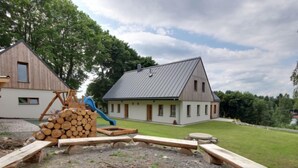 A rustic cabin with a metal roof, a wooden deck, and a blue slide. - U Krále by Interhome (Kořenov)