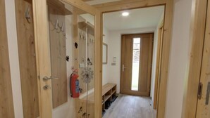 Ein Flur mit Holztüren, einem Feuerlöscher und einer Sitzbank.