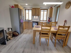 Compact kitchen with oven, dining table, and window above the sink.