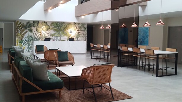 A modern lounge area with seating, tables, and a mural wall. - Primeway Suites Cebu (Cebu City)