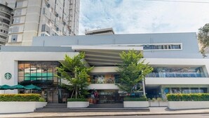 A modern building with a Starbucks on the ground floor, a visible staircase, and a glass facade. - Primeway Suites Cebu (Cebu City)