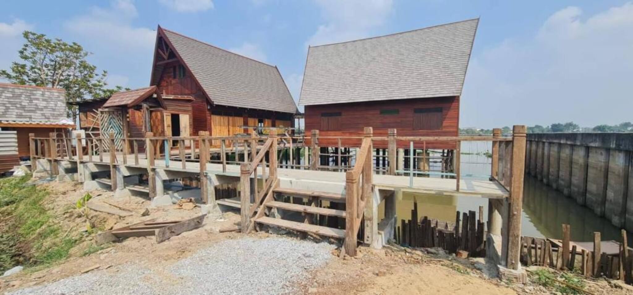 Un edificio rústico de madera con techo inclinado y un muelle de madera que se adentra en el agua.