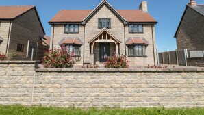 A stone house with a central entrance, multiple windows, and a brick chimney. - Homeland (Somerton)
