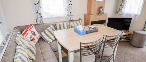 Una sala de estar acogedora con sofá, mesa de comedor y televisor.