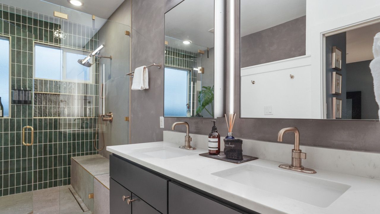Een moderne badkamer met twee wastafels, een grote spiegel en een douchecabine.