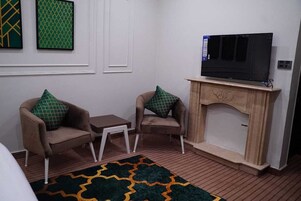 Deluxe Room | Living area | 45-inch LED TV with cable channels