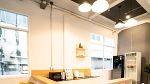 A modern kitchen with a central island, bar stools, and built-in appliances. - PIER 808 Hostel (Bangkok)