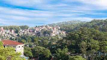 A hillside town with densely packed buildings and lush green trees.