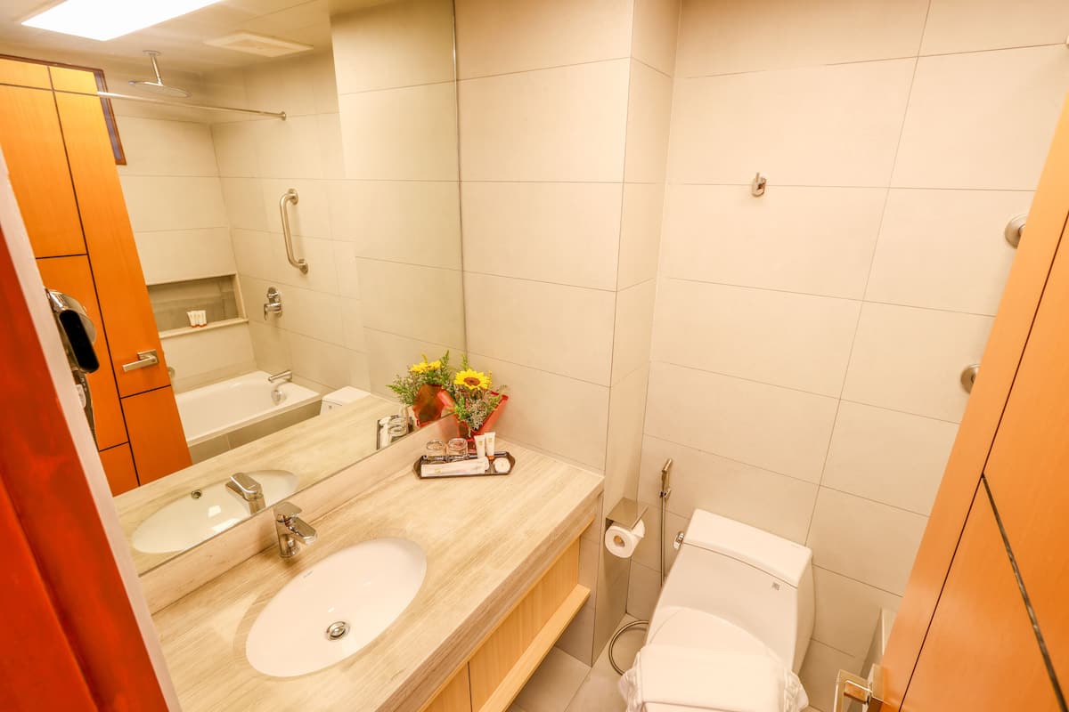 Un baño con lavamanos doble, inodoro y ducha.
