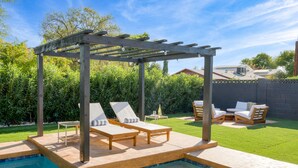 A backyard with a pool, wooden pergola, and outdoor seating area. - Element by AvantStay | Pool, Firepit, Game Room (Scottsdale)