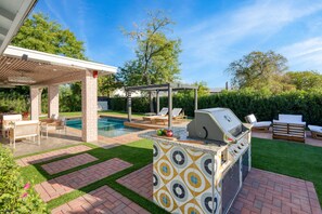 An outdoor patio with a grill, seating, and a pool. - Element by AvantStay | Pool, Firepit, Game Room (Scottsdale)