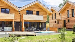 A modern wooden house with a swimming pool, outdoor seating, and a covered patio. - #6b mit Sauna & Pool by Interhome (Sankt Georgen am Kreischberg)
